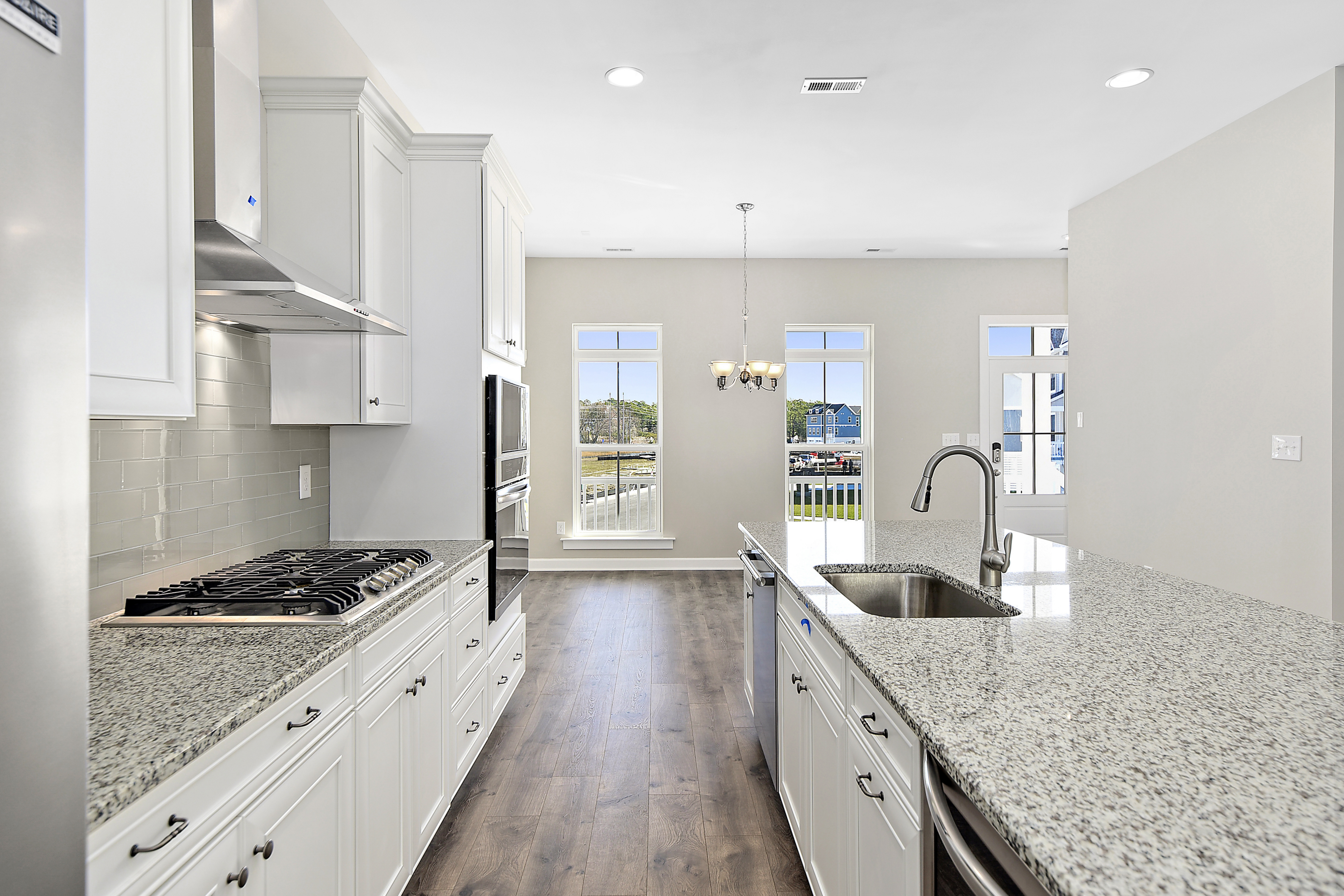 Kitchen sink, stove top, granite countertops and large center island in the chef's kitchen