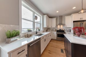 Gourmet kitchen with white perimeter cabinets and dark island cabinets at Brewer's Crossing