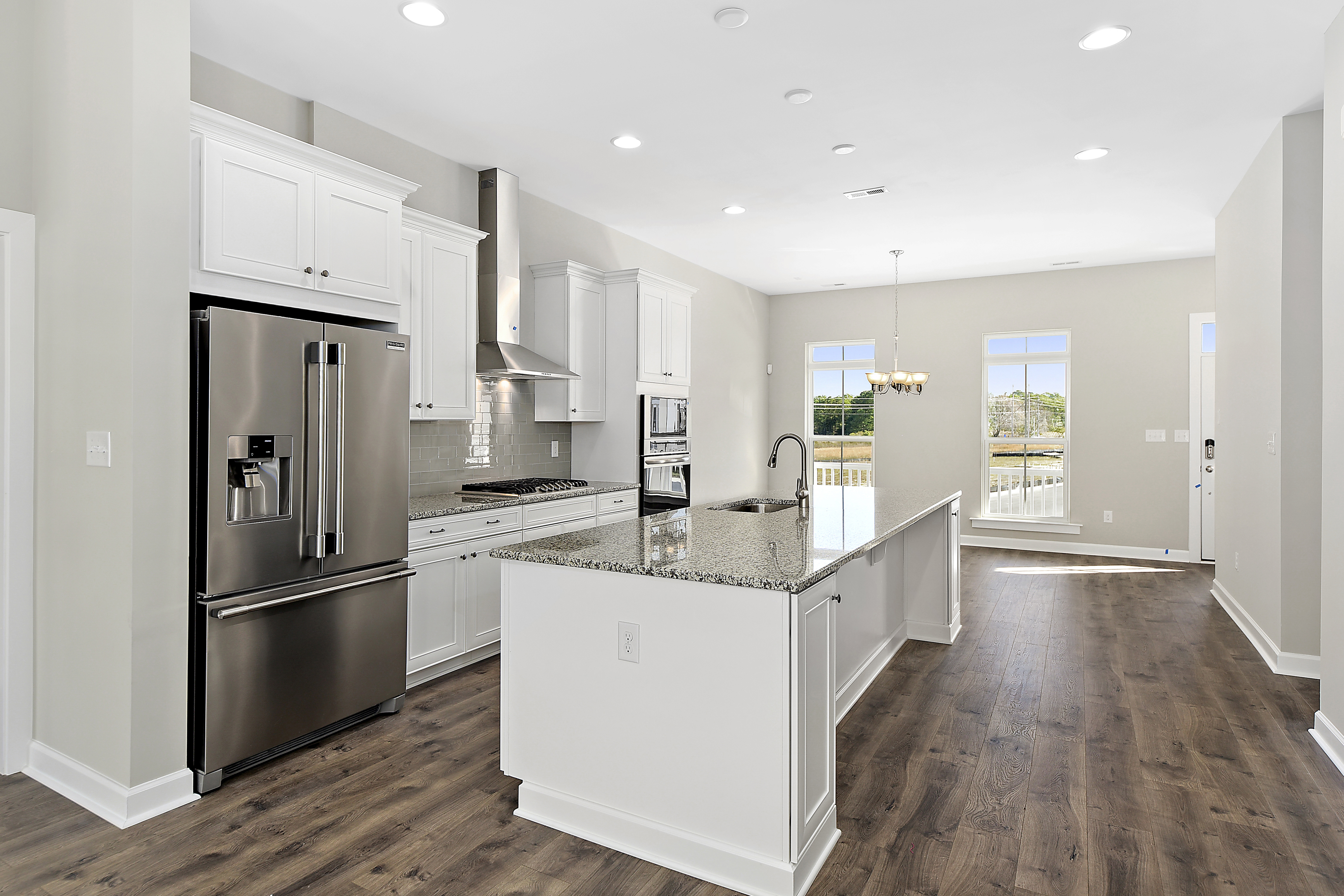 Spacious kitchen with large white center island and stainless steel appliances