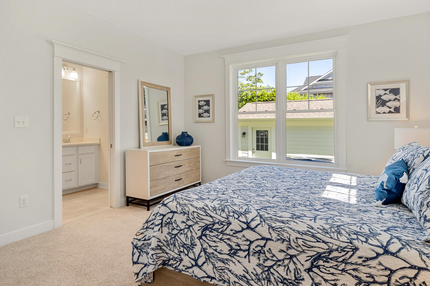 Staged Bedroom with Large Bed, Dresser and Large Exterior Windows