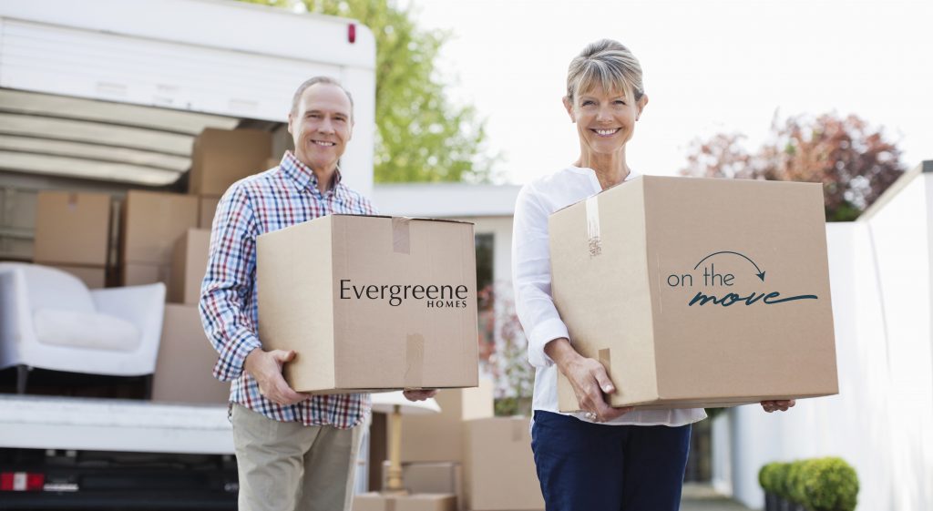 Two people moving out with Evergreene Homes boxes in hand