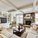 Spacious and naturally lit family room with coffered ceilings and built in storage