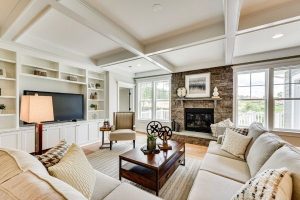 Spacious and naturally lit family room with coffered ceilings and built in storage