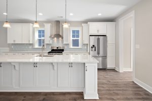 Gourmet kitchen with white cabinets in new build home by Evergreene Homes