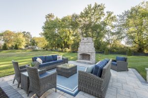 Outdoor living area with couches and fireplace at Delaware beach home