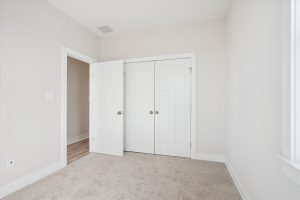 Secondary bedroom with modern furnishings in the Linwood floor plan.