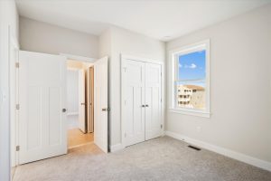 Secondary bedroom with modern furnishings in the Linwood floor plan.