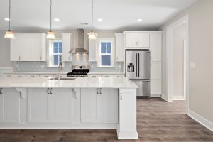 Gourmet kitchen with white cabinets in new build home by Evergreene Homes