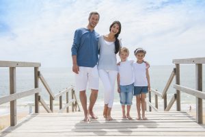Happy,Family,Standing,On,A,Wood,Pontoon,In,Front,Of